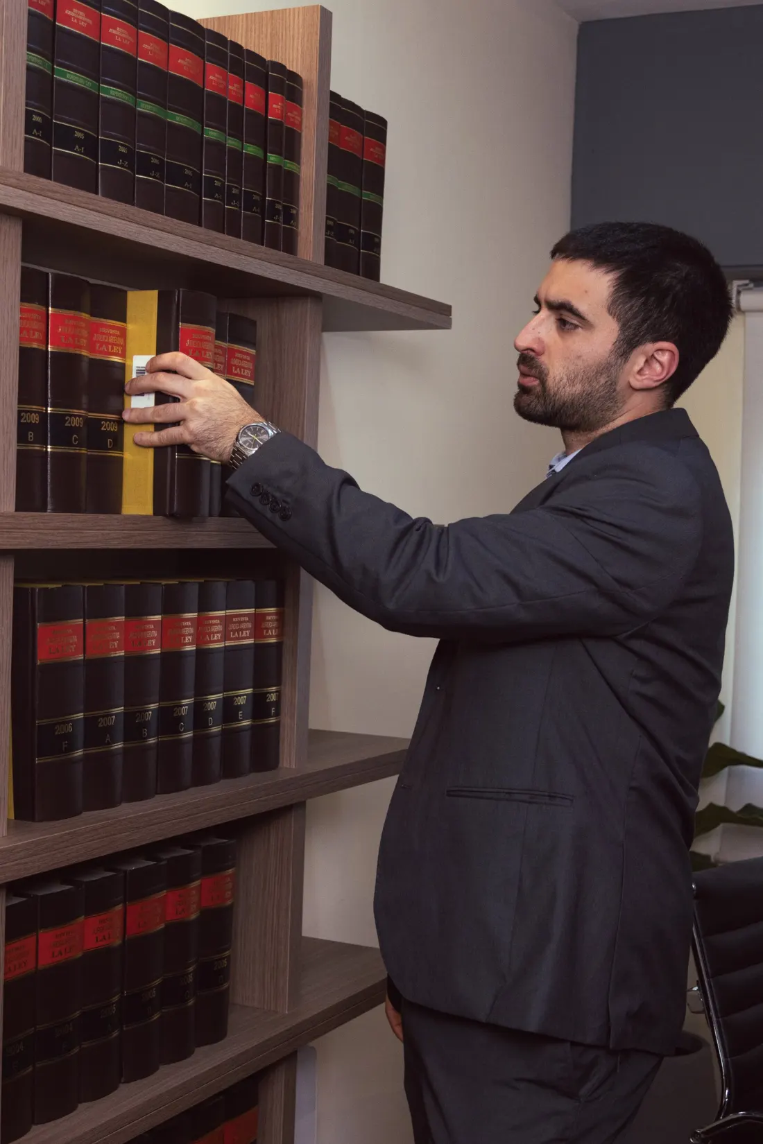 Bruno Meucci, abogado, consultando un tomo de jurisprudencia en la biblioteca del estudio